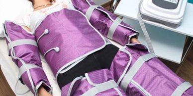 Person undergoing a body slimming treatment with purple compression wraps.