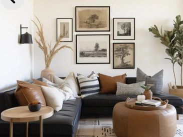 Cozy living room with black sofa, brown ottoman, and neutral-toned decor.