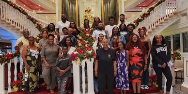 A large group posing on a decorated staircase for a festive photo.