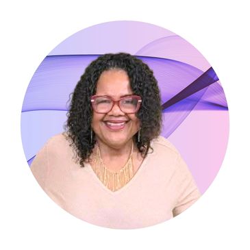Smiling woman with curly hair and glasses against a purple abstract background.