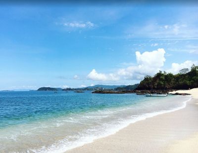 A peaceful beach with clear blue water and a bright sky.