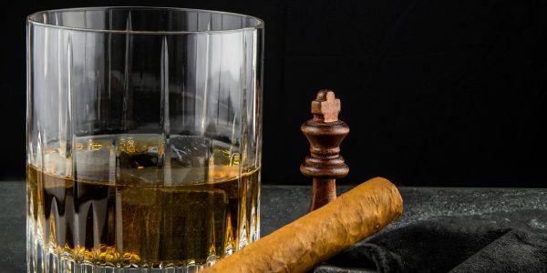 Whiskey glass, chess king, and cigar.