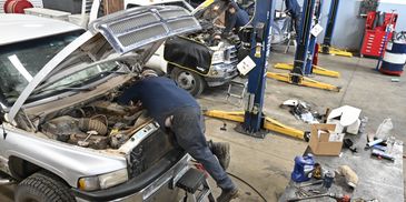 Mobile Diesel Service service bay with mechanics working on diesel pickups.
