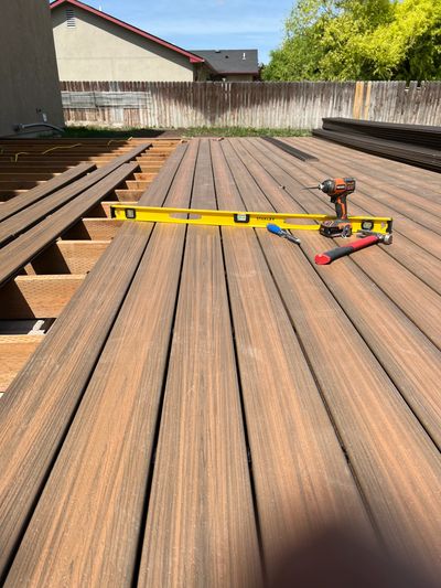 Wooden decking under construction with tools and a level on top.
