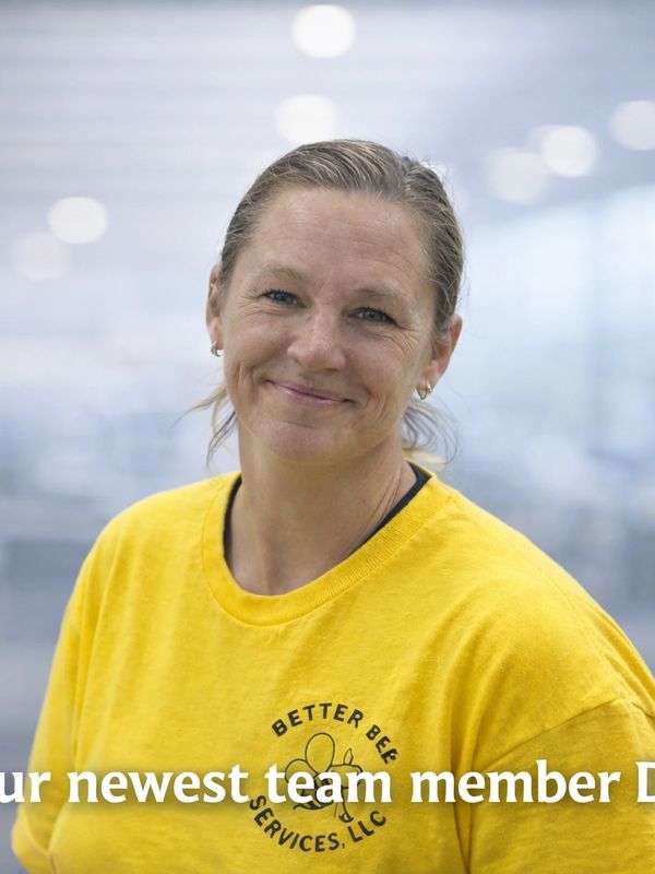 A smiling woman in a yellow shirt welcoming a new team member.