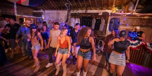 Group line dancing in a rustic bar.
