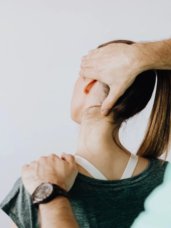 A person receiving a neck adjustment from a therapist.