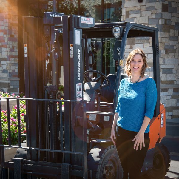 PROPOSALand's founder, Kim Sheldon, standing with construction equipment.