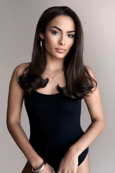Confident woman in black bodysuit with elegant hairstyle.
