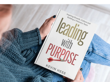 Person holding the book 'Leading with Purpose' by Kevin Hess.