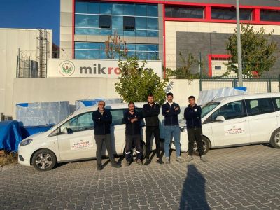 Mikro firmasının önünde servis araçları ve çalışanlar.
