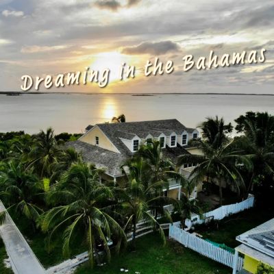 Sunset view over a house with palm trees in the Bahamas.
