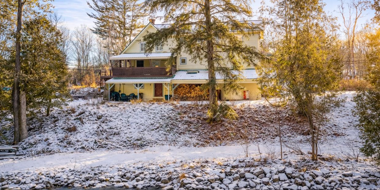 Snow-covered house surrounded by trees.