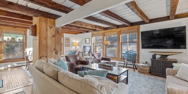 Cozy living room with rustic wooden beams and comfortable seating.