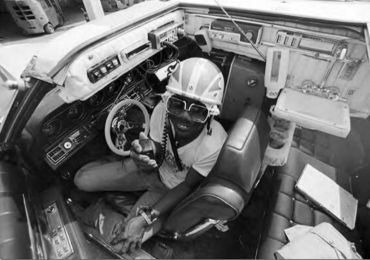 Person in a racing helmet inside a cockpit.