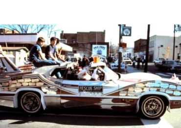 Modified rescue ship car with people sitting on it.
