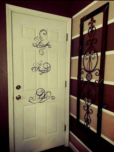 Striped accent wall painted in chocolate, khaki, and white. Vinyl decal lettering on the door. 