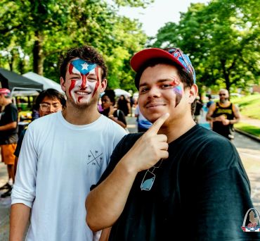 Two men with face paint at an outdoor event.