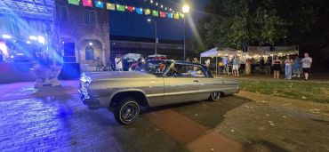 Classic car at a nighttime event with colorful lights.