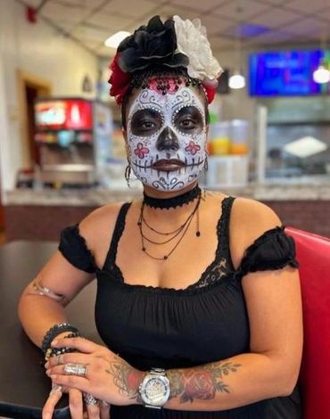 Person with Day of the Dead face paint and floral headpiece.