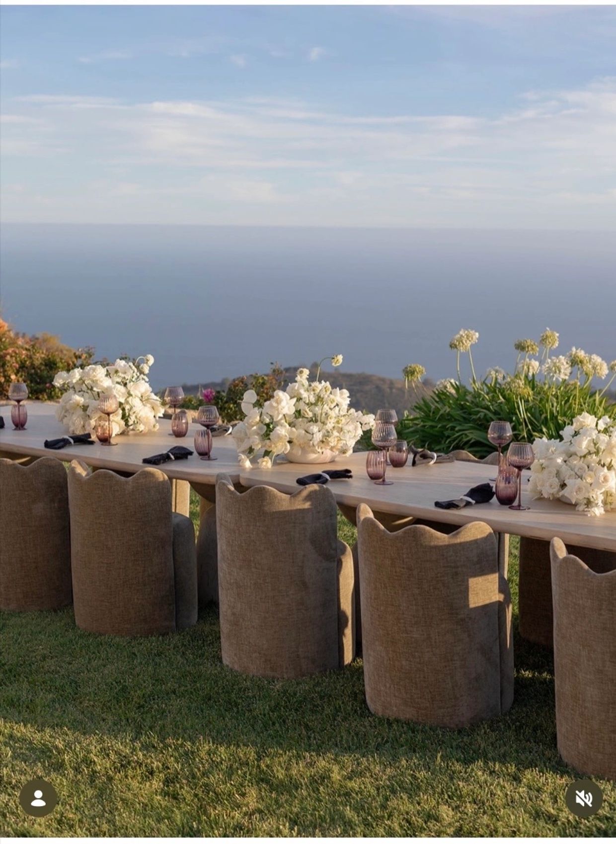 Outdoor dining table with ocean view and elegant decorations.