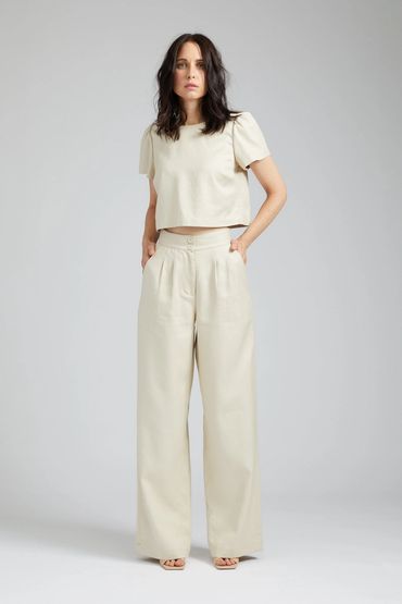 Woman in beige top and wide-leg pants.