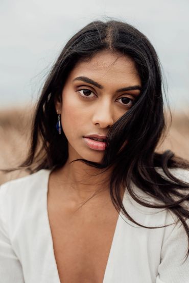 Portrait of a woman with long dark hair and a white top.