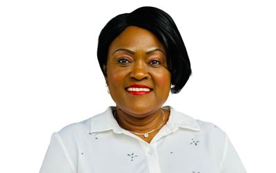 Smiling woman in a white blouse against a plain background.