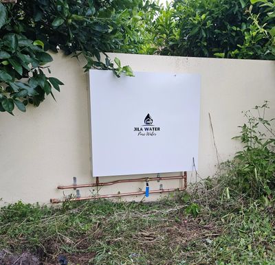 A whole house water filter with a stainless steel housing and a Colorbond housing