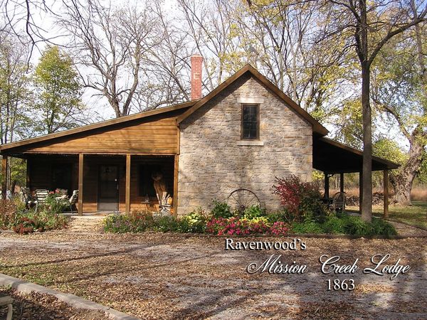 Rustic stone and wood lodge surrounded by autumn trees and garden.