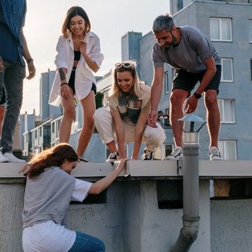 Woman climbing a roof in an outdoor parkour fitness class