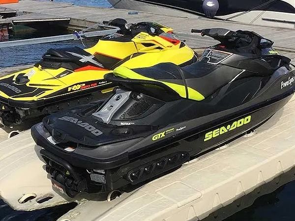 Two Wave Armor Jet Ski or PWC Ports side by side with yellow and black PWC's stored on them. 