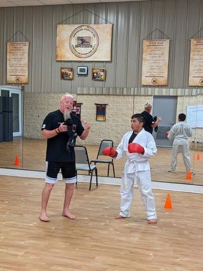Martial arts instructor and student in a dojo preparing for training.
