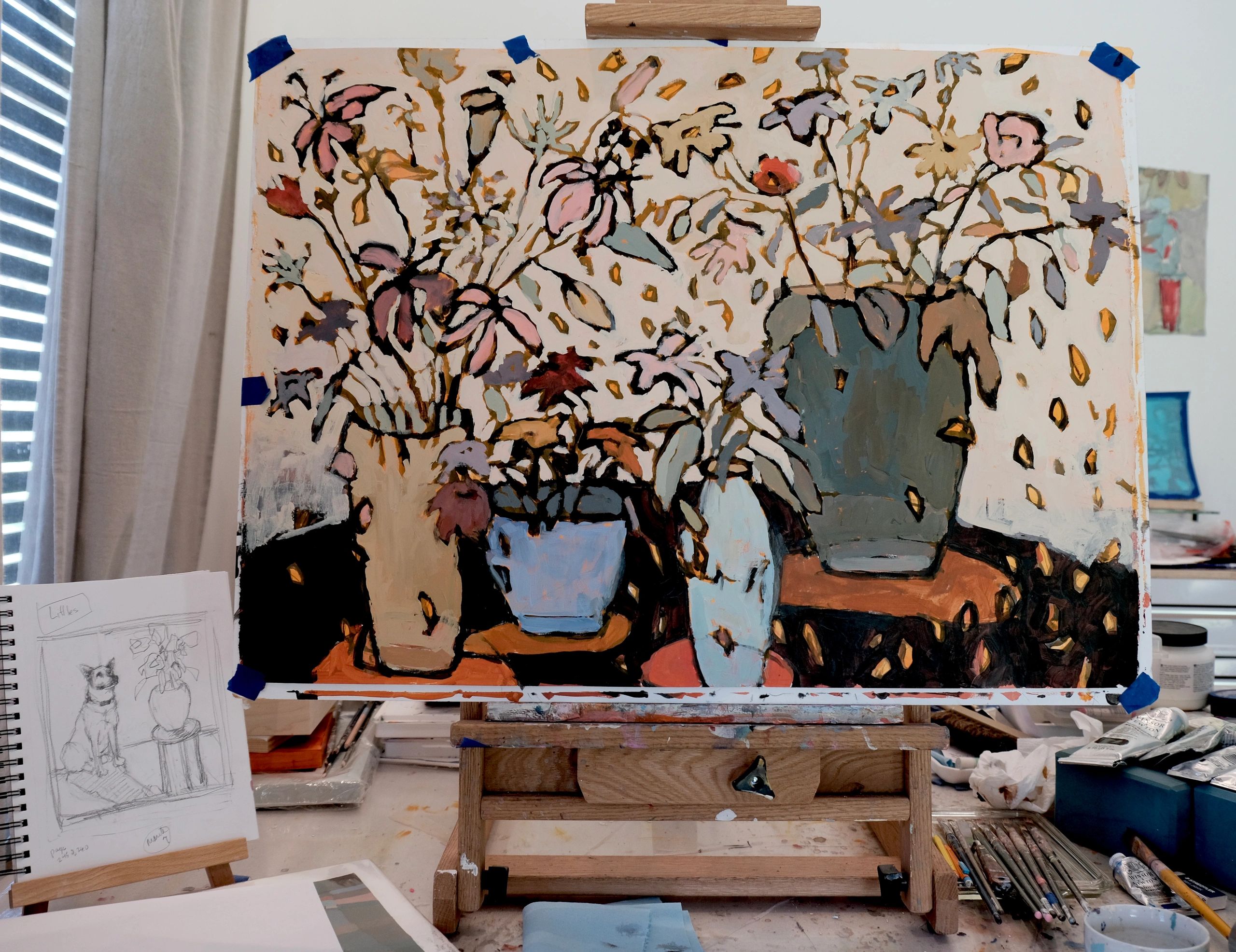 Abstract floral painting on an easel in an artist's studio.