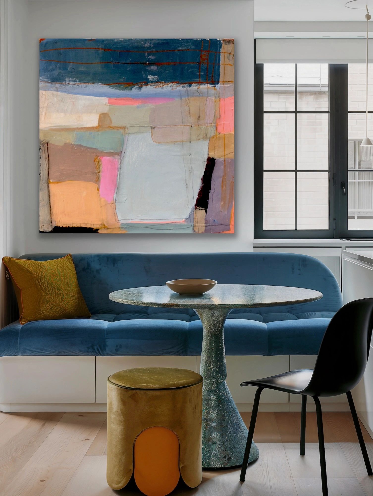 Modern dining nook with abstract art and blue velvet seating.