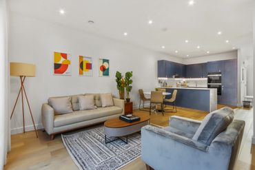 Modern open-plan living room and kitchen with stylish furniture and decor.