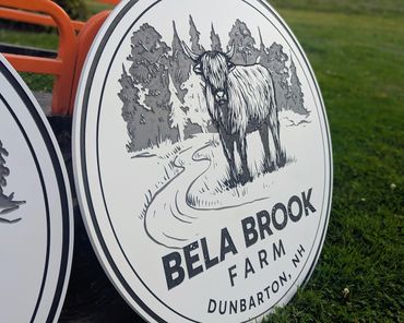 Sign for Bela Brook Farm featuring a Highland cow illustration.