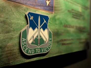 Close-up of a military emblem with 'Ascend to Victory.'