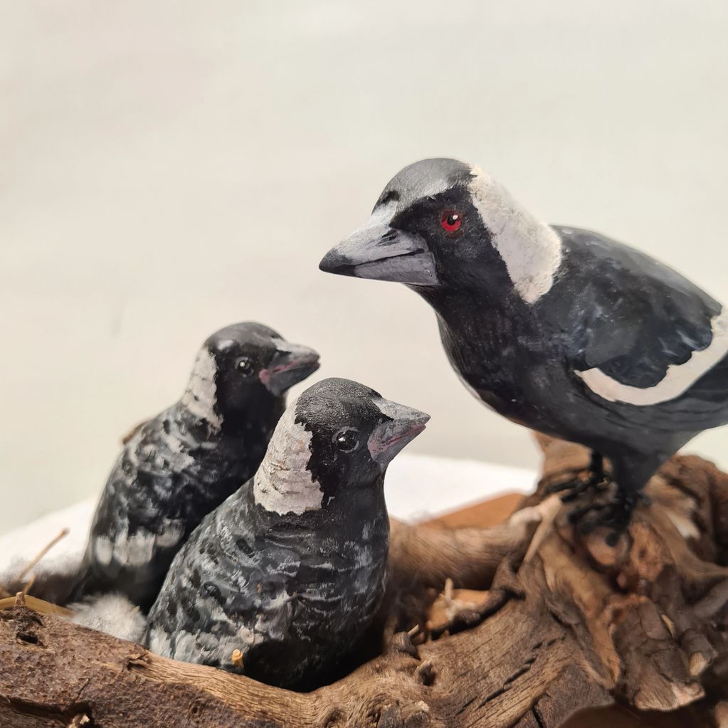 Hand carved & painted wooden magpie with two hand carved and painted baby magpies in nest