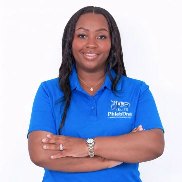 Woman in blue PhlebDna shirt smiling with arms crossed.
