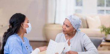 Nurse consulting with a patient wearing a headscarf.