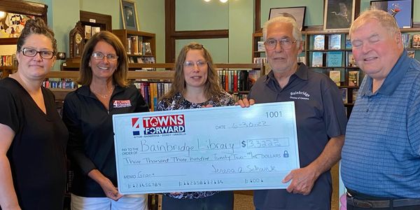 Five people holding a huge check