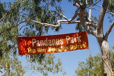 A red banner for Pandanus Park hanging between tree branches.