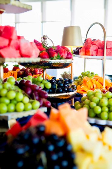 Assorted fresh fruits on tiered trays.