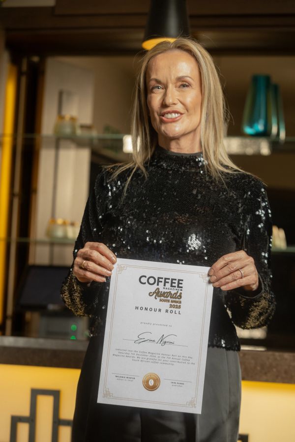 Woman holding a Coffee Magazine Awards certificate.