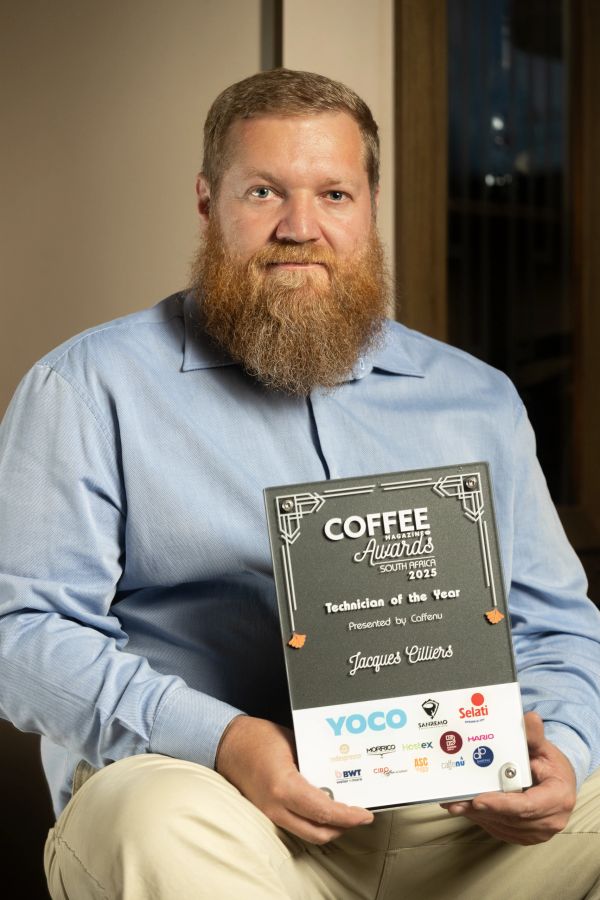 Man with a beard holding a Coffee Magazine Awards plaque.