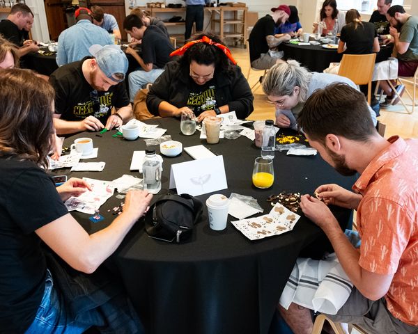 People focused on assembling puzzles around a table in a group setting.