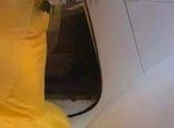 Photo of bride and groom entering luxury vehicle