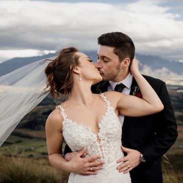 Bride and Group kissing on a mountain top at their destination wedding