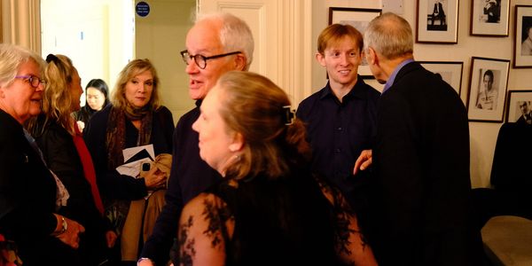 People engaging in conversation at a social gathering indoors.